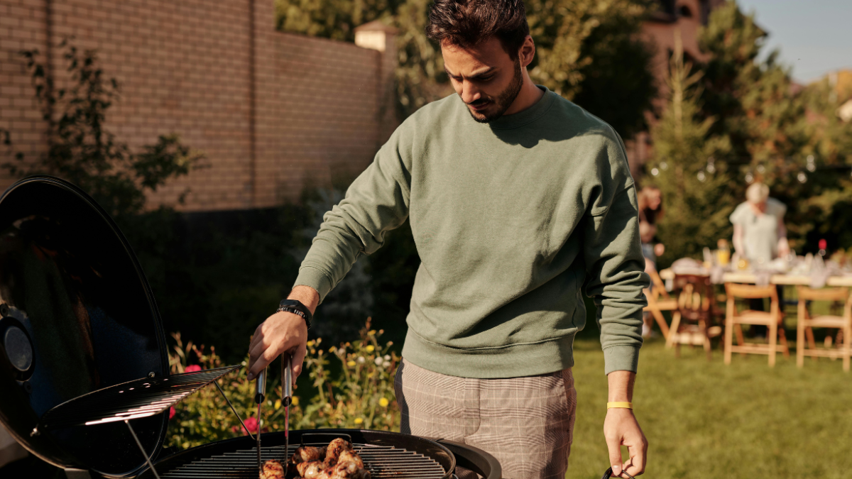 Man cooking meat on a barbecue at home to control calories and portion sizes