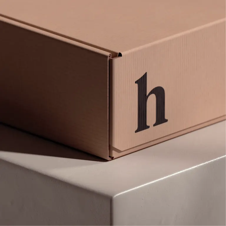 A plain cardboard box marked with a Hims logo