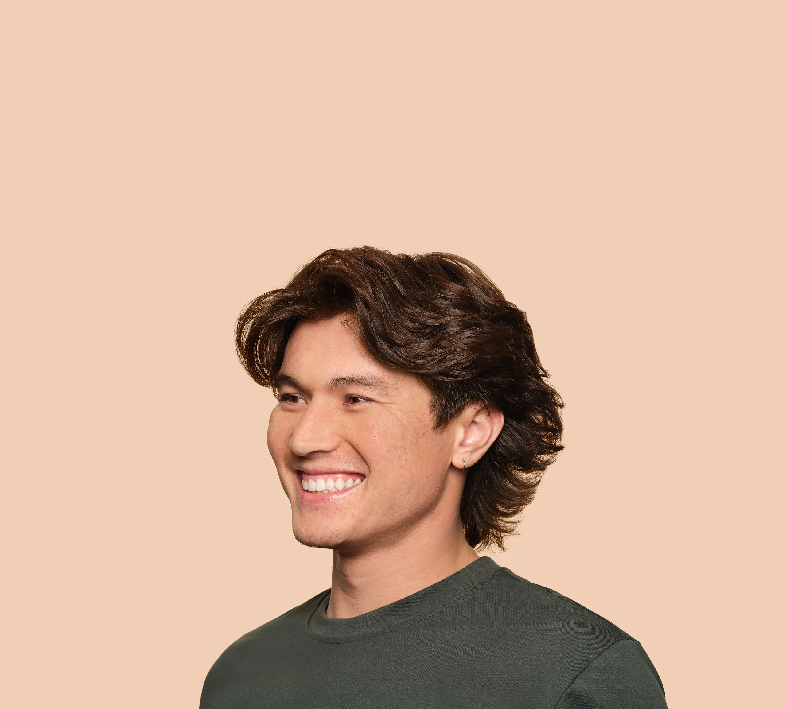 Young man with great hair smiles off camera