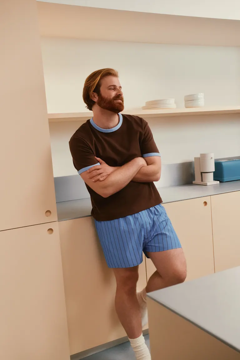 Man standing in kitchen looking happy