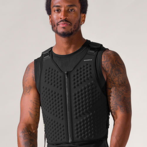Studio portrait of an athletic man wearing a black weight vest, the OMORPHO G-vest