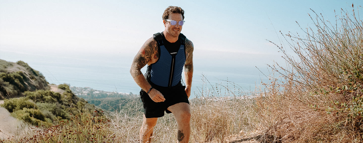 CDP Cover - Desktop - G-Vest - Man hikes through hills in OMORPHO Ocean weight vest for men and black G-Shorts