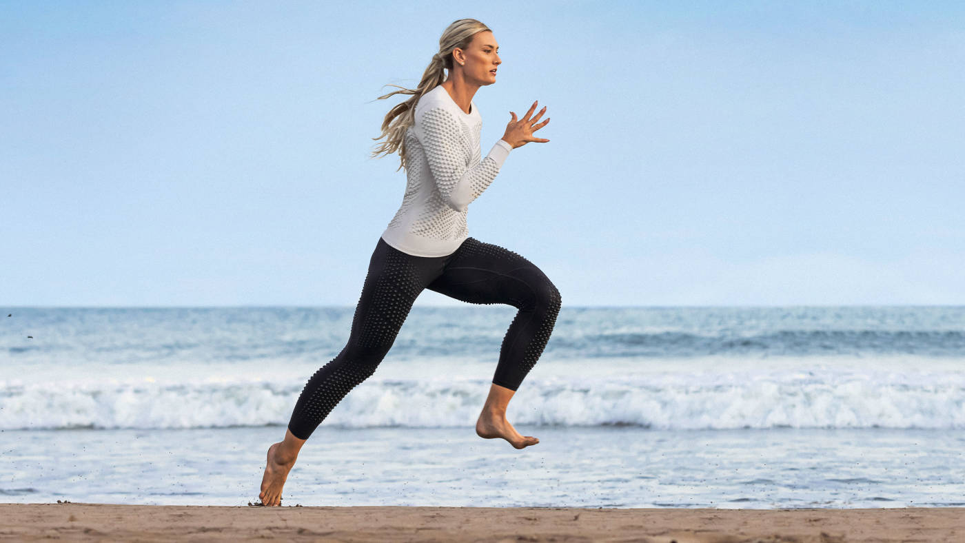 Olympian heptathlete Annie Kunz running on the beach using OMORPHO workout gear