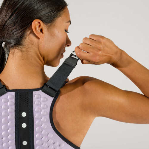 Shoulder detail view of woman adjusting the lavender g-vest weighted vest for women by OMORPHO