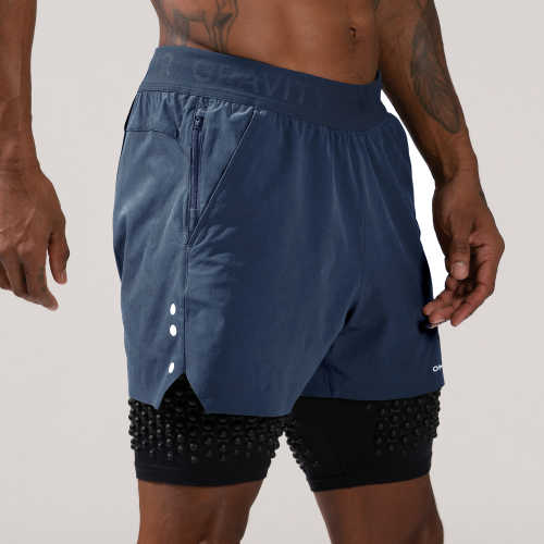 Man standing in OMORPHO G-Short 2-in-1 weighted workout shorts in blue color Ocean.