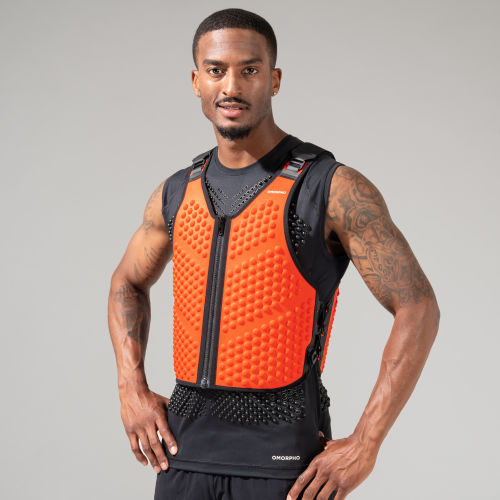 Full body view of man jumping in orange weighted workout vest, the OMORPHO Fire G-Vest.