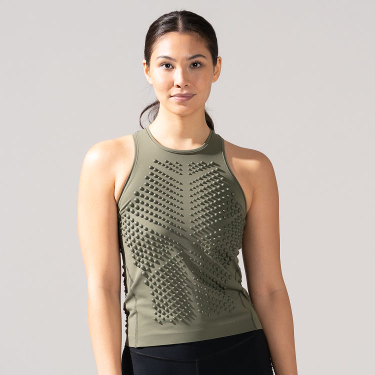Indoor studio portrait of a woman wearing the OMORPHO Olive G-Tank athletic top