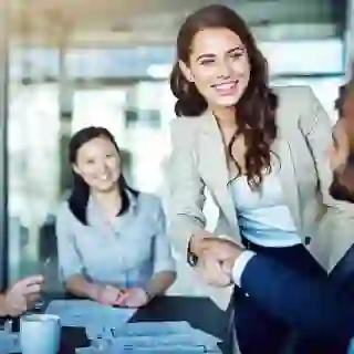 Smiling woman shaking hands at a business meeting