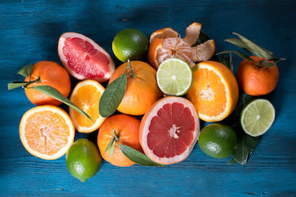 蓝木桌上放着柑橘类水果。