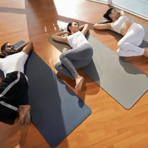 在瑜伽课上做脊髓扭曲的三个人。