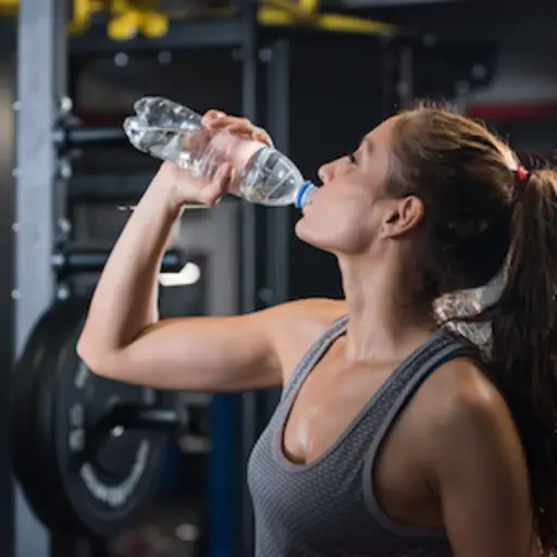 在健身房的妇女饮用水。