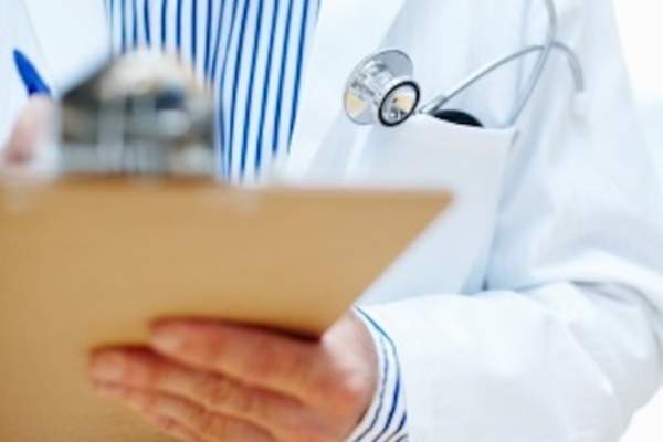 医生拿着和剪贴板上写。