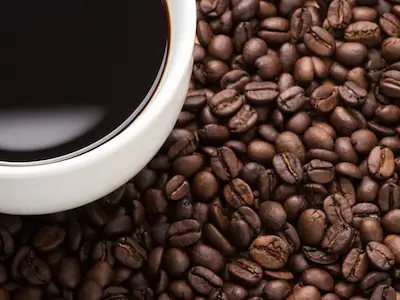 一杯咖啡放在烤好的咖啡豆上。