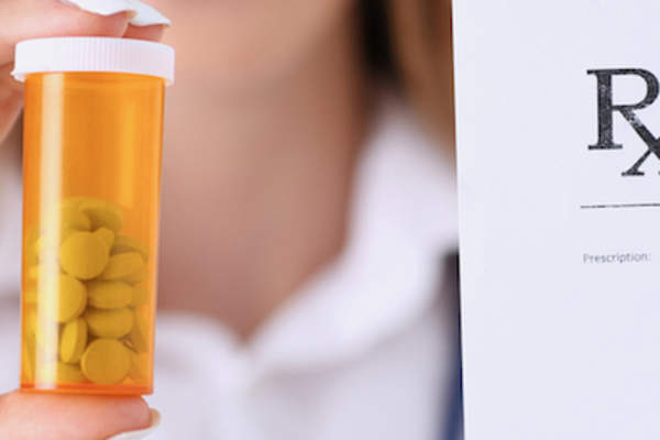 医生拿着处方笺和丸。