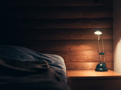 黑暗的卧室，床头柜上有灯