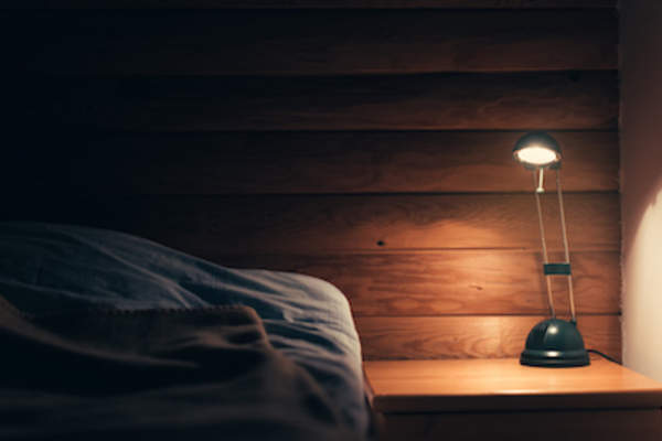 黑暗的卧室,床头柜上有灯