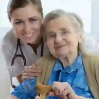 Smiling nurse and senior woman with cane.