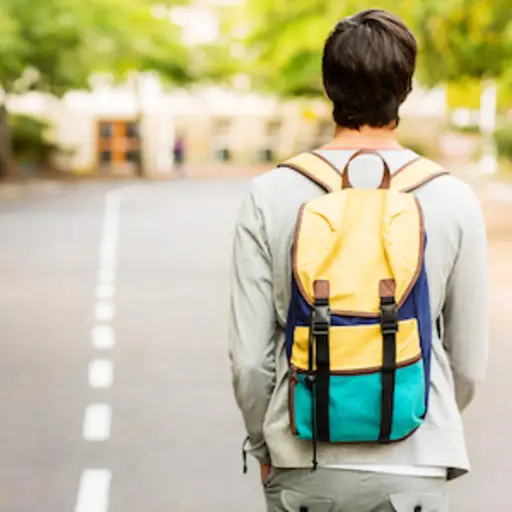 Boy walking to school wearing backpack with both straps