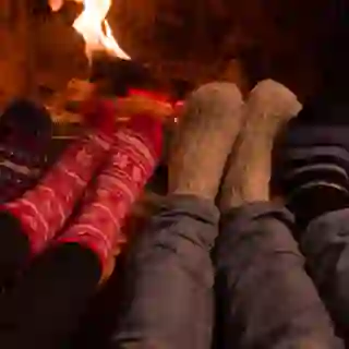 feet in warm socks in front of fireplace