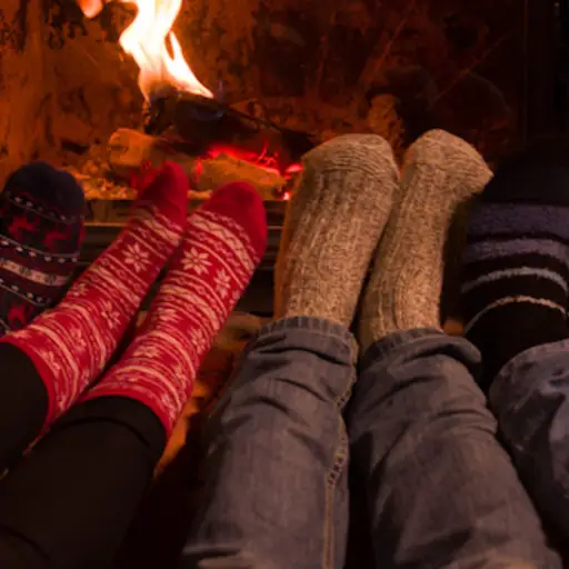 在壁炉前的温暖袜子的脚