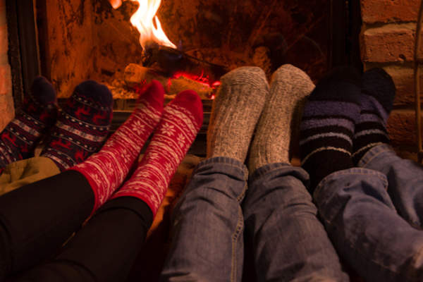 脚穿暖和的袜子站在壁炉前