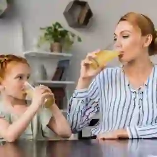 Mother and daughter drinking orange juice.