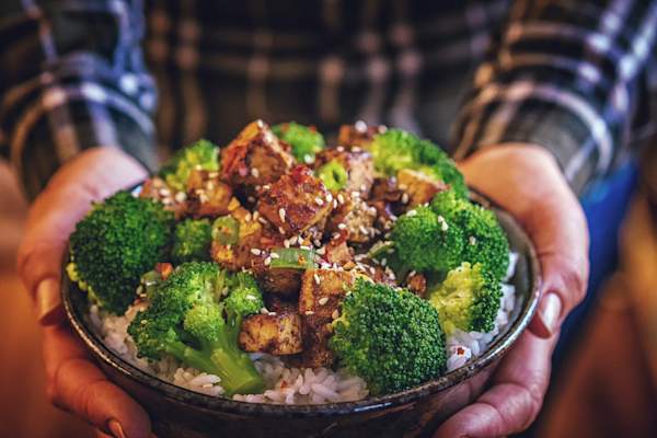 在米饭上烤豆腐和西兰花。