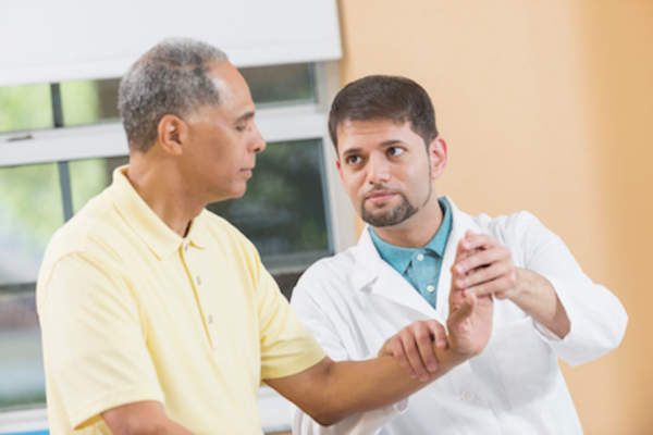 医生检查芒手类风湿性关节炎。