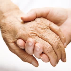 老年人的手牵着年轻人的手。