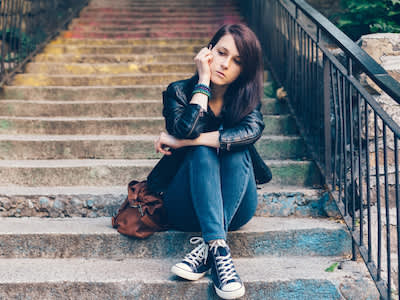 沮丧的年轻女子坐在楼梯上。