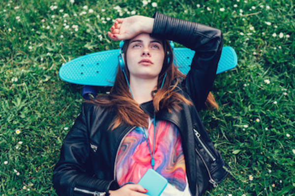 女子趴在公园听音乐。