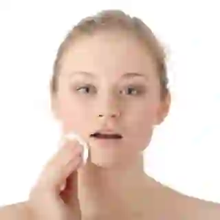 Young women removing makeup with cotton wipe.