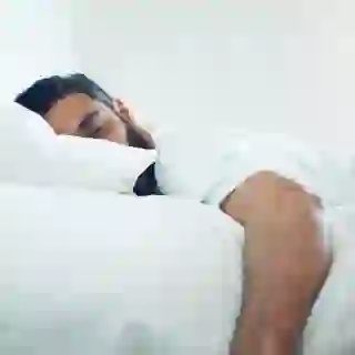 Man sleeping soundly on bed.