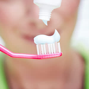 把牙膏挤到牙刷上。