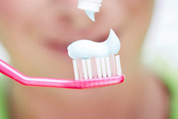 把牙膏挤到牙刷上。