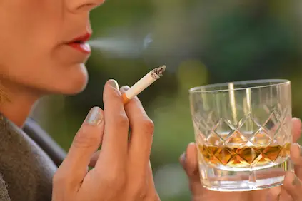妇女抽烟和喝苏格兰威士忌酒