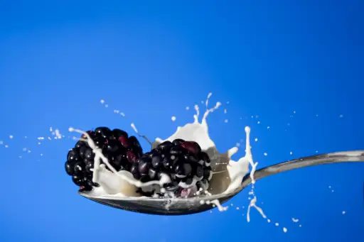 在勺子图像上的牛奶黑莓