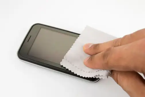 男人用纸巾擦手机。