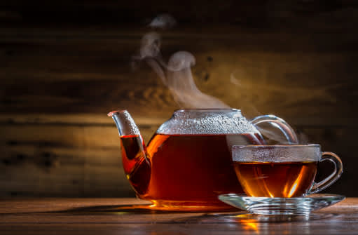 玻璃茶杯和茶壶都盛满了热气腾腾的茶