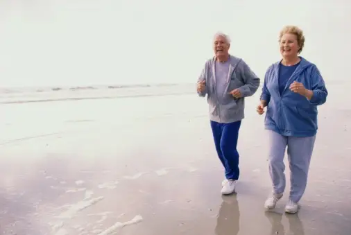 一对老夫妇在沙滩上慢跑