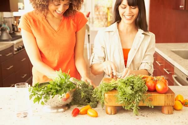 两个女人准备一餐用大量vegtables的