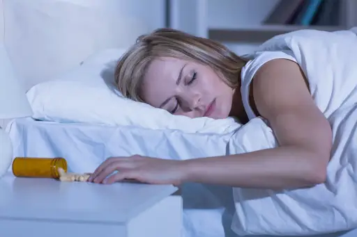 一个女人把药放在床头柜上睡觉