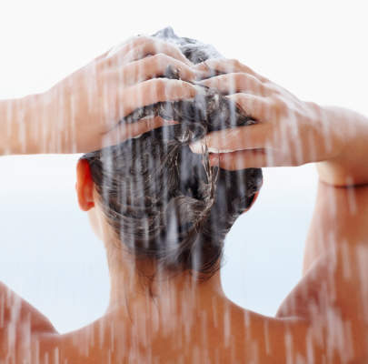 妇洗她的头发在淋浴
