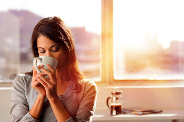 年轻女子喝咖啡的早晨。