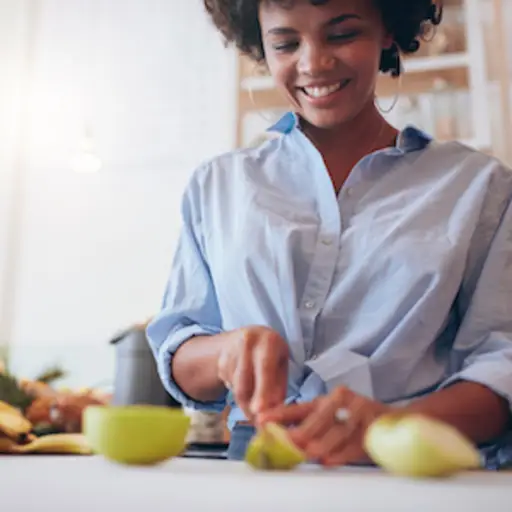 Woman cutting up fruit with rolled up sleeves