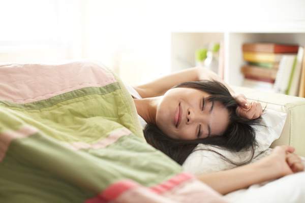 年轻女子仰面睡觉,头侧向一边。