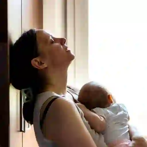 疲惫的母亲抱着孩子，闭上眼睛