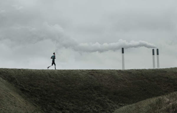 背景是空气污染的人在跑步