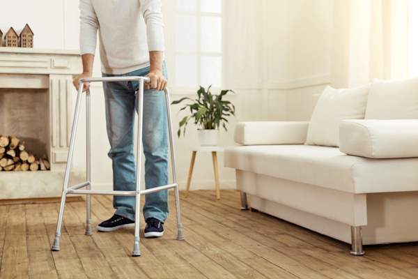 年轻男子站在学步车使用客厅