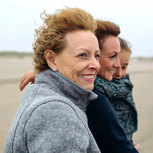 三代女人在沙滩上散步。